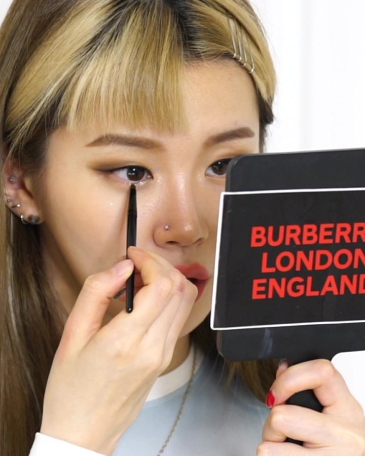 Minjeong dotting glitter just under her lower lashes